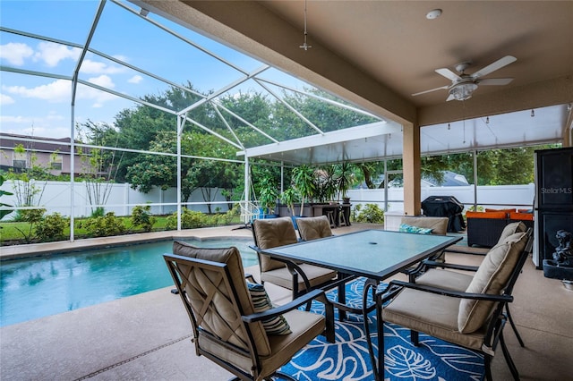 view of swimming pool featuring ceiling fan, a lanai, and a patio