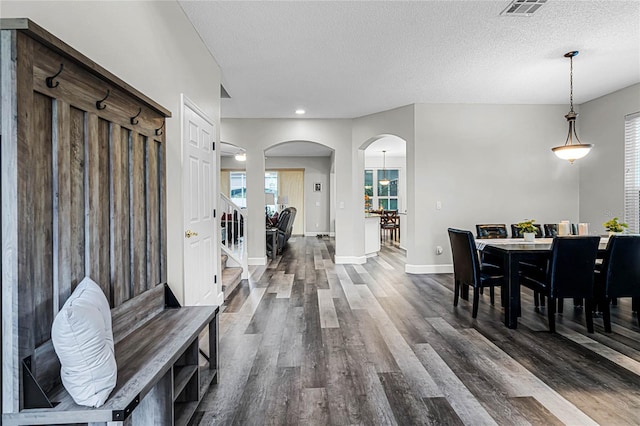 dining area with dark wood-type flooring and a textured ceiling