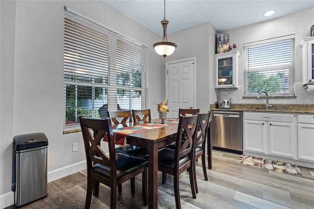 dining room with sink, light hardwood / wood-style flooring, and plenty of natural light