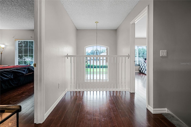 interior space featuring a textured ceiling, hardwood / wood-style floors, and a chandelier