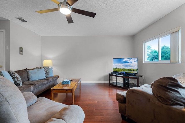 living room with dark hardwood / wood-style flooring, a textured ceiling, and ceiling fan