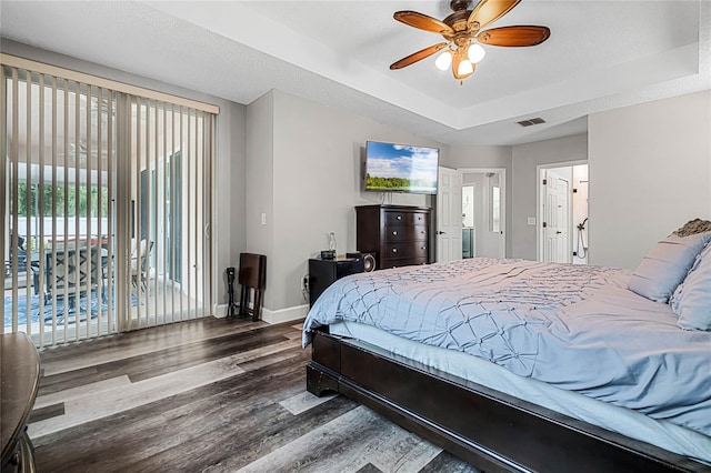 bedroom featuring a tray ceiling, ceiling fan, access to outside, and wood-type flooring