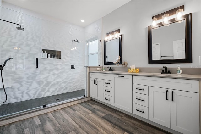 bathroom featuring a shower with shower door, hardwood / wood-style flooring, and vanity