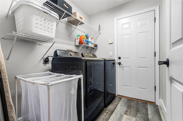 clothes washing area with independent washer and dryer and dark wood-type flooring