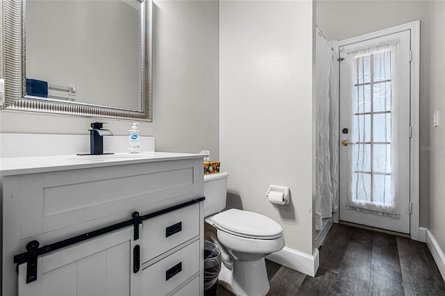 bathroom with plenty of natural light, vanity, hardwood / wood-style floors, and toilet