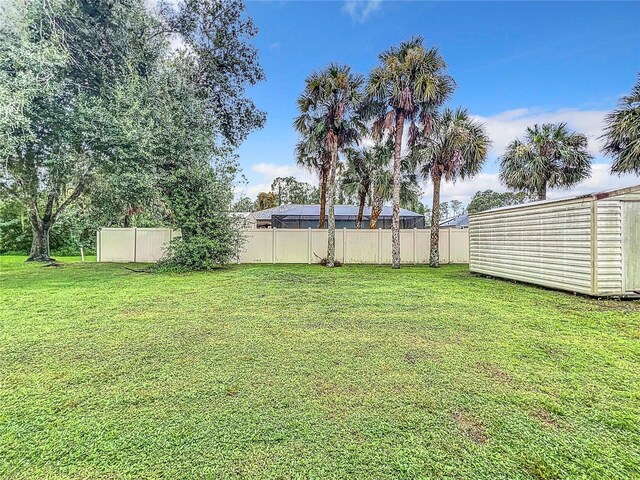 view of yard featuring an outbuilding and fence