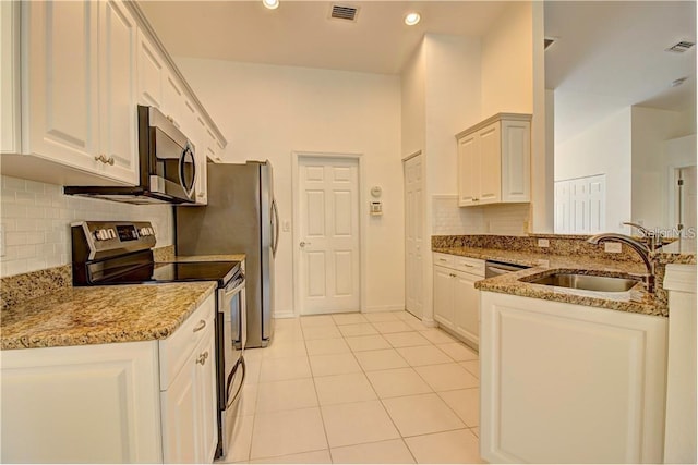 kitchen with light stone counters, light tile patterned floors, visible vents, appliances with stainless steel finishes, and a sink