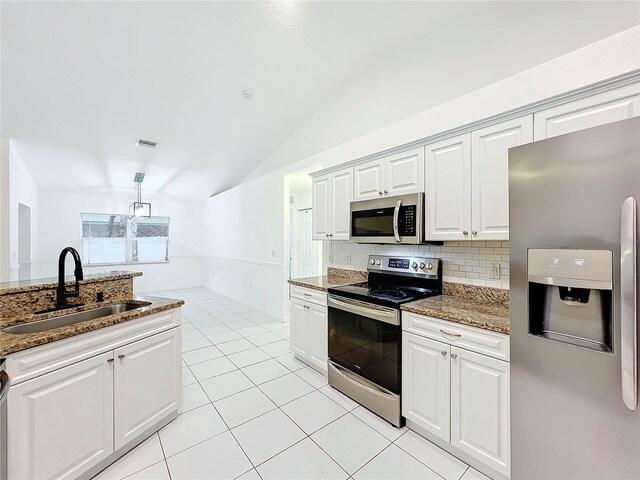 kitchen with visible vents, decorative backsplash, lofted ceiling, appliances with stainless steel finishes, and a sink