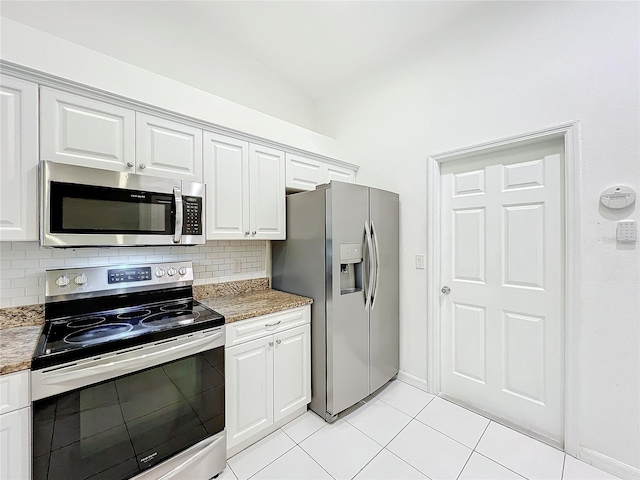 kitchen featuring light stone counters, light tile patterned flooring, white cabinetry, appliances with stainless steel finishes, and backsplash