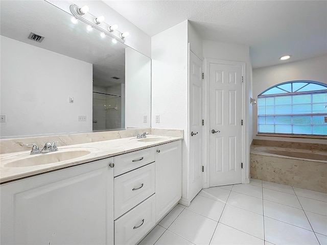 bathroom with visible vents, a sink, a garden tub, and double vanity