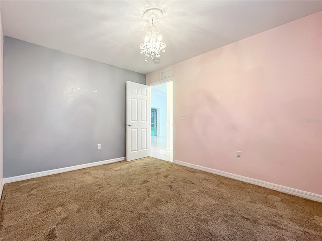 empty room with light carpet, a chandelier, visible vents, and baseboards