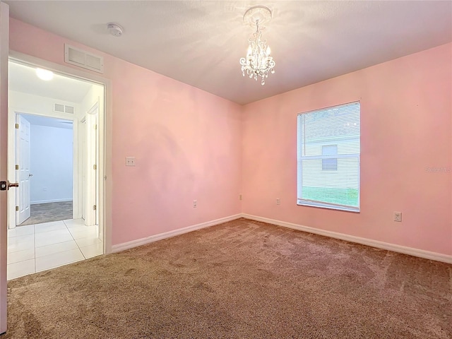 carpeted spare room featuring baseboards, tile patterned flooring, visible vents, and a notable chandelier