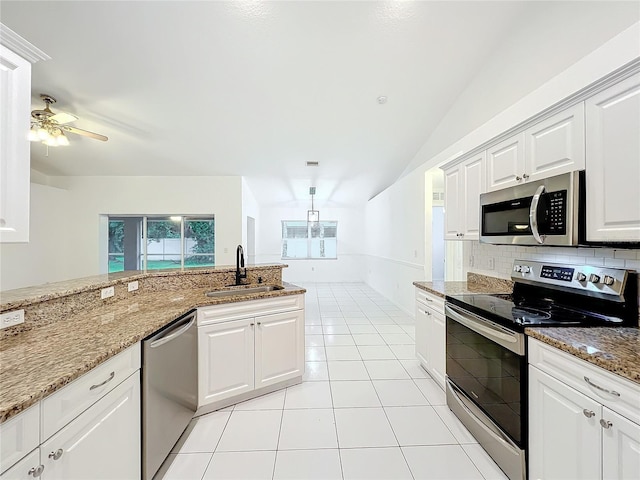 kitchen with light tile patterned flooring, stainless steel appliances, a sink, white cabinets, and tasteful backsplash