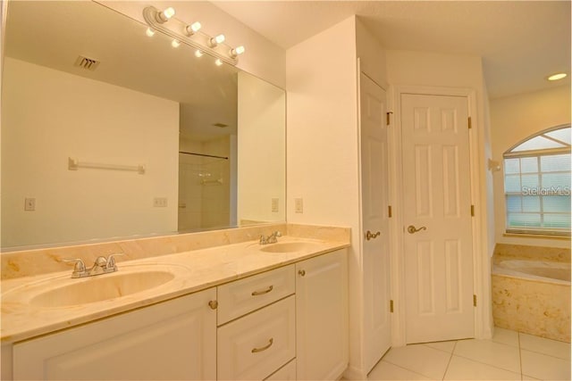 bathroom featuring double vanity, tile patterned floors, visible vents, a sink, and a bath