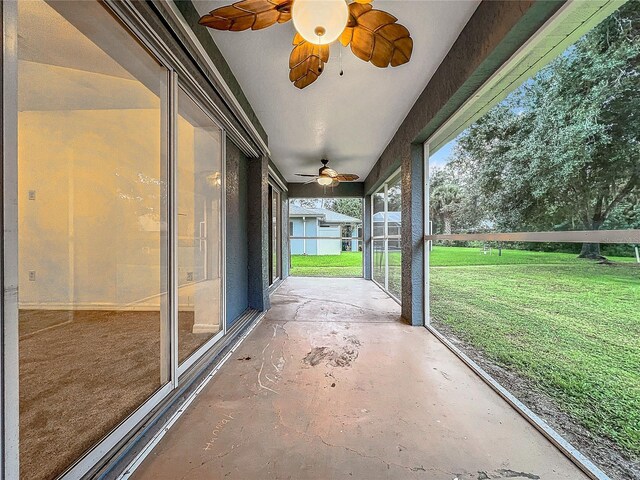 unfurnished sunroom featuring a ceiling fan