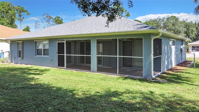 rear view of house with roof with shingles, a yard, and stucco siding