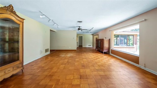 spare room with a ceiling fan, track lighting, visible vents, and baseboards