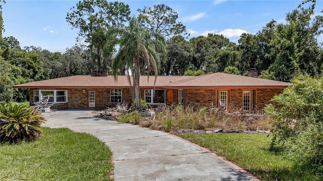 ranch-style home with a front lawn and a chimney