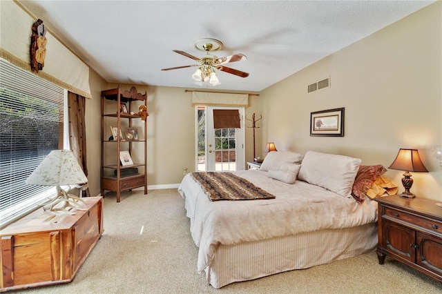 carpeted bedroom featuring visible vents, baseboards, ceiling fan, access to exterior, and a textured ceiling