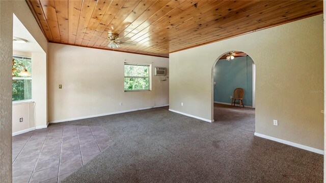 carpeted empty room with arched walkways, crown molding, wood ceiling, ceiling fan, and baseboards