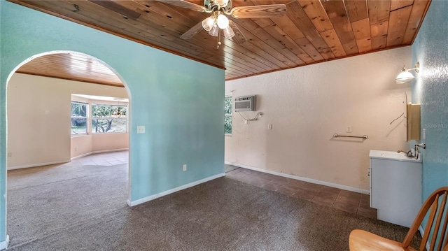 carpeted spare room featuring arched walkways, crown molding, a ceiling fan, an AC wall unit, and wooden ceiling