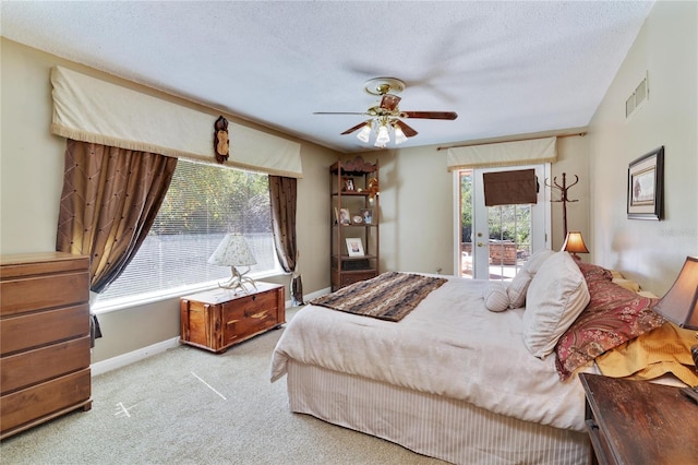 bedroom with baseboards, visible vents, light colored carpet, access to outside, and a textured ceiling