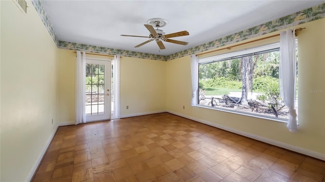 spare room with visible vents, ceiling fan, and baseboards