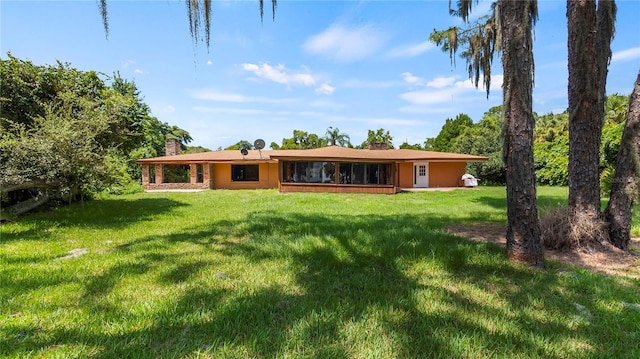 back of property with a lawn and a chimney