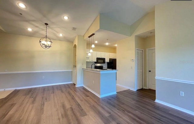 kitchen with white cabinetry, black appliances, lofted ceiling, and wood-type flooring