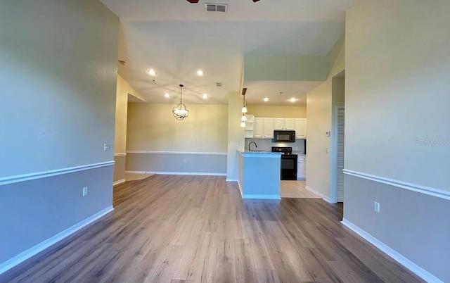 unfurnished living room with light hardwood / wood-style flooring, ceiling fan, and sink