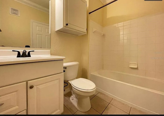 full bathroom with tiled shower / bath, tile patterned floors, toilet, vanity, and ornamental molding