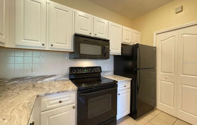 kitchen featuring white cabinets, light tile patterned floors, light stone countertops, black appliances, and tasteful backsplash