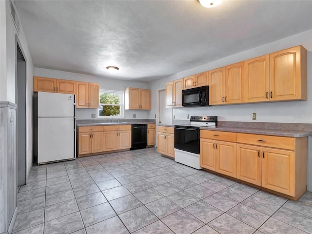 kitchen featuring black appliances, light tile patterned flooring, light brown cabinets, and sink