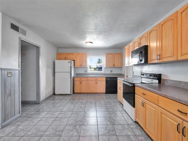 kitchen with black appliances, light brown cabinetry, light tile patterned floors, and sink