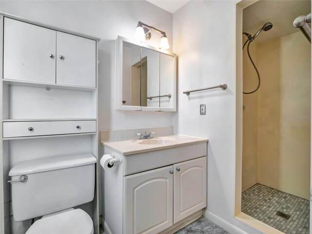 bathroom featuring toilet, vanity, and a tile shower