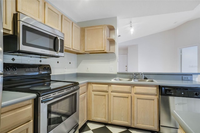 kitchen with light brown cabinetry, light floors, light countertops, stainless steel appliances, and a sink