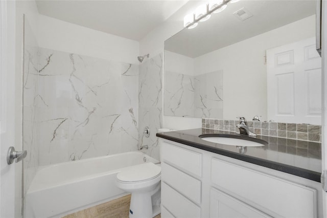 full bathroom featuring hardwood / wood-style flooring, tiled shower / bath, toilet, and vanity