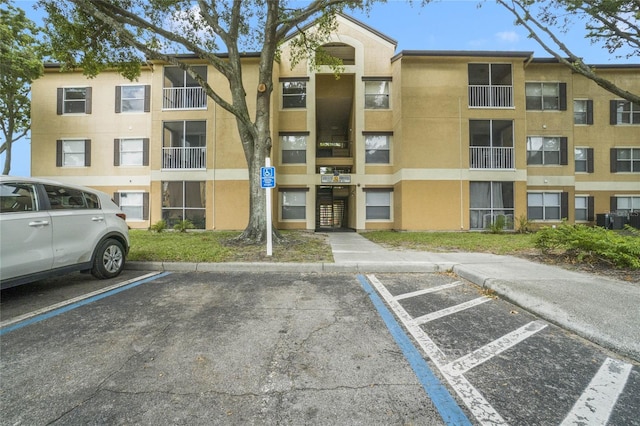 view of property featuring cooling unit and uncovered parking