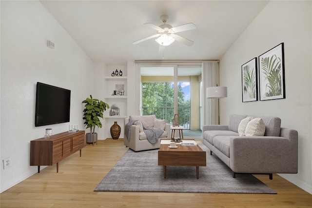 living room featuring ceiling fan, light hardwood / wood-style flooring, lofted ceiling, and built in features