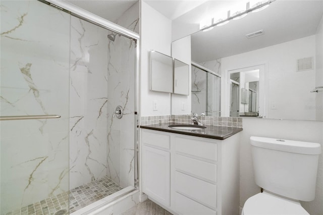 full bath with vanity, toilet, visible vents, and a marble finish shower