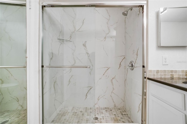 bathroom featuring a shower with door and vanity