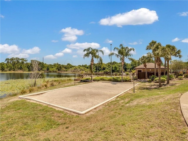 view of property's community featuring a lawn, volleyball court, and a water view