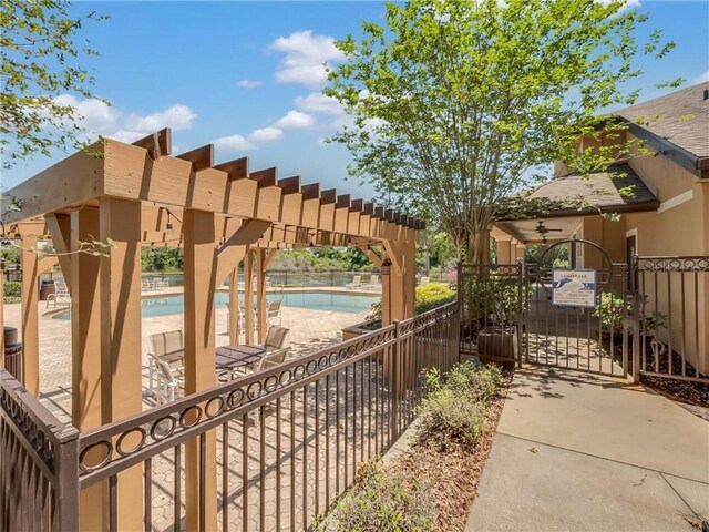 view of gate featuring a pergola and a community pool