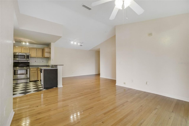 unfurnished living room with light tile patterned flooring, sink, vaulted ceiling, track lighting, and ceiling fan