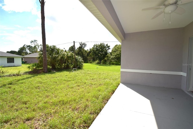 view of yard with ceiling fan and a patio