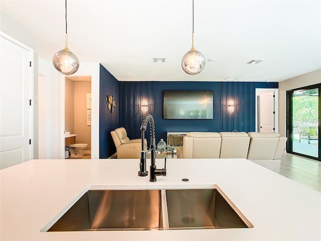 kitchen with sink, tile patterned flooring, and decorative light fixtures