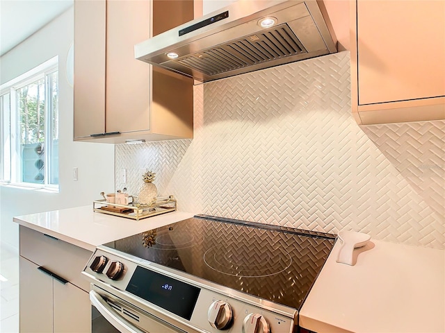 kitchen with stainless steel electric stove, gray cabinetry, and tasteful backsplash