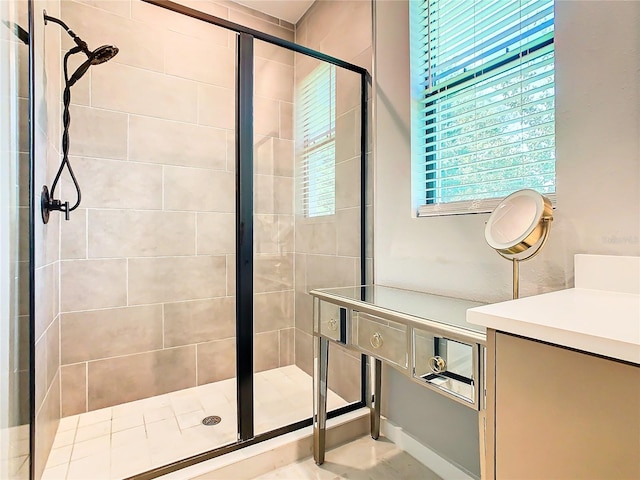 bathroom with a shower with shower door and vanity