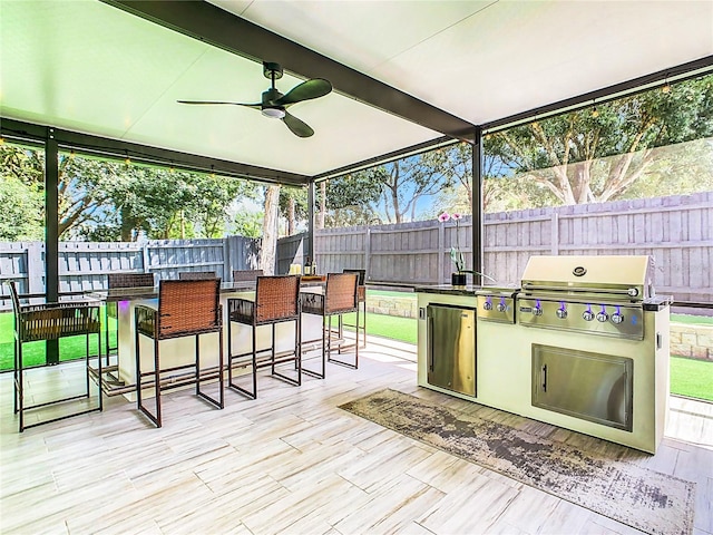 exterior space featuring ceiling fan, a grill, and exterior kitchen