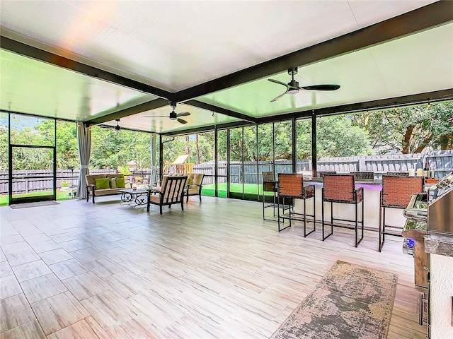 sunroom / solarium with ceiling fan and beam ceiling